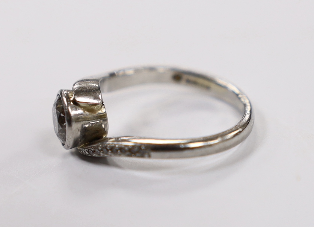 A modern platinum and collet set single stone diamond ring with diamond chip set crossover shoulders, size K, gross weight 5.5 grams